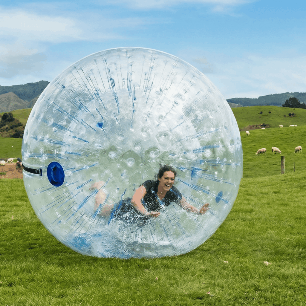 Mensch in einer aufblasbaren Plastikkugel rollt den Berg herunter