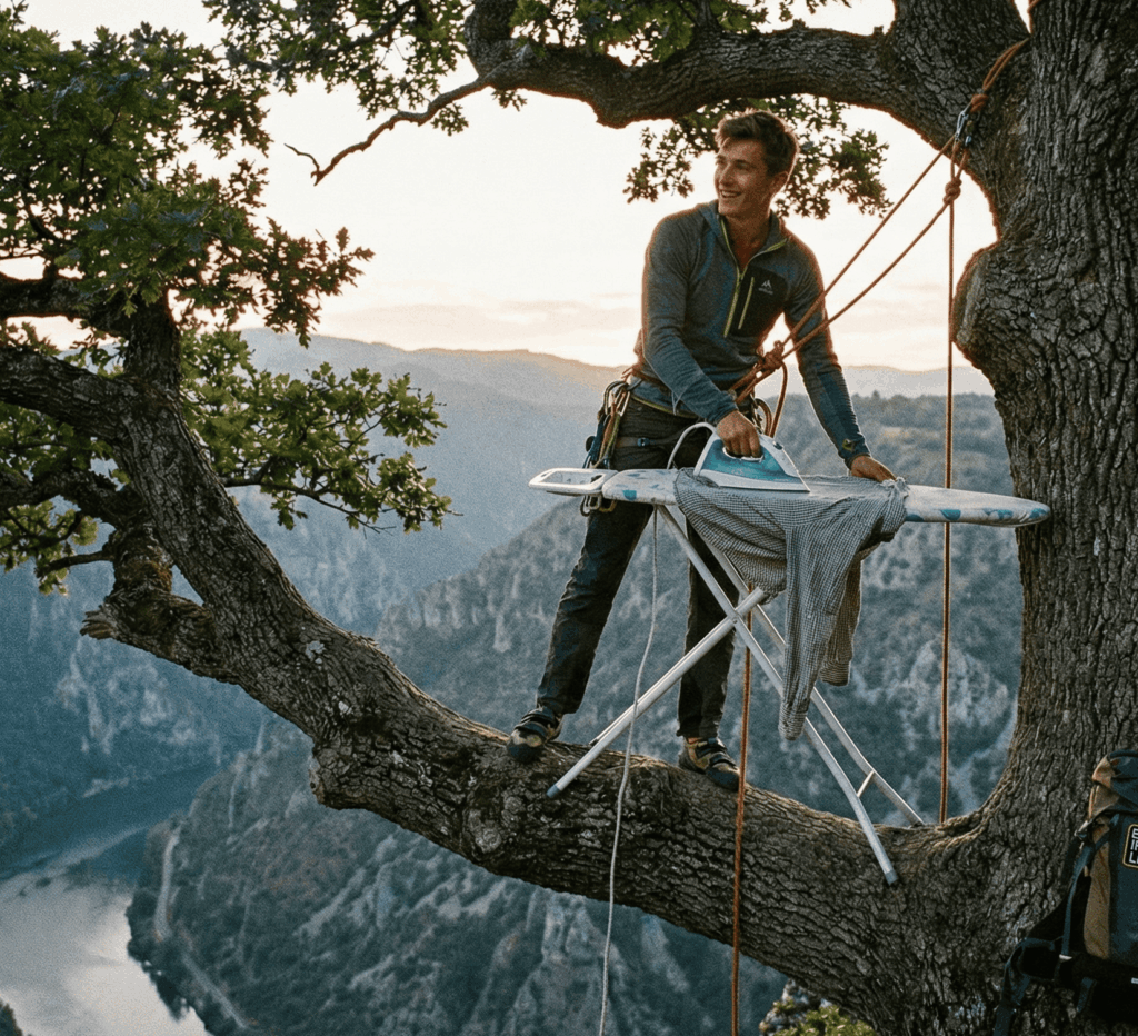 Ein Mann steht mit einem Bügelbrett auf einem Baum und bügelt