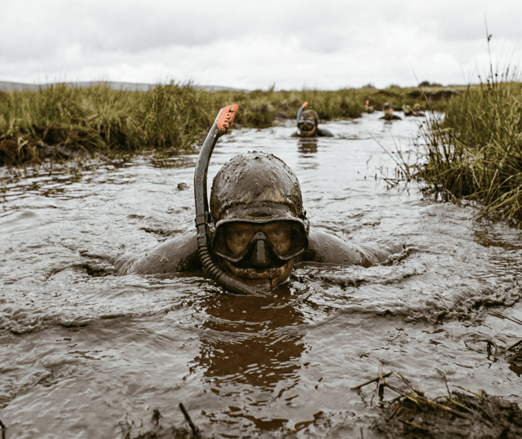 Eine Person schnorchelt durch einen matschigen Fluss